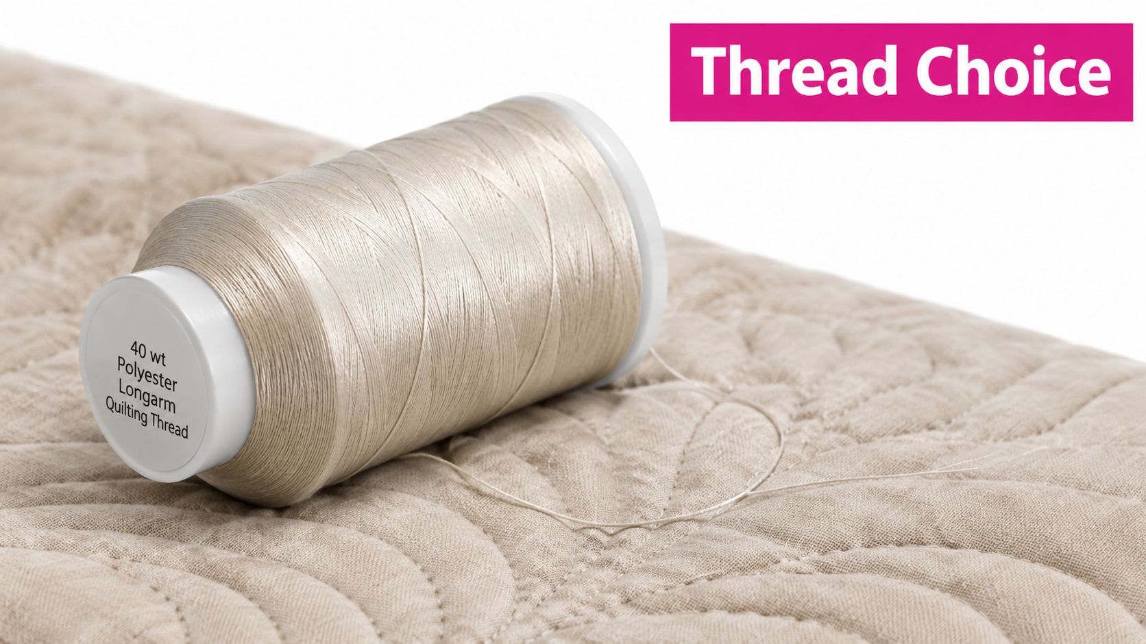 A spool of beige 40 weight polyester longarm quilting thread resting on a textured, stitched quilt fabric.