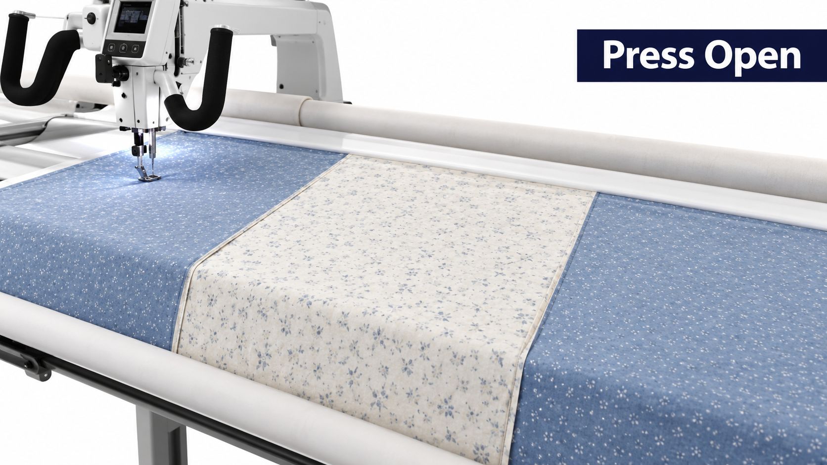 A longarm quilting machine stitching patterned fabric panels together on a professional quilting frame.