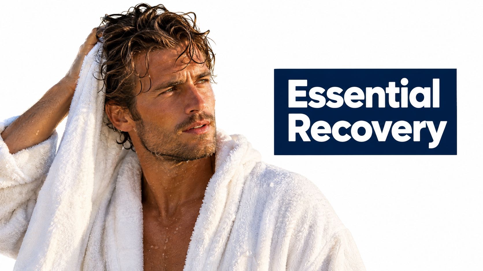 A handsome man with wet hair wearing a white terry cloth robe, drying his hair after showering.