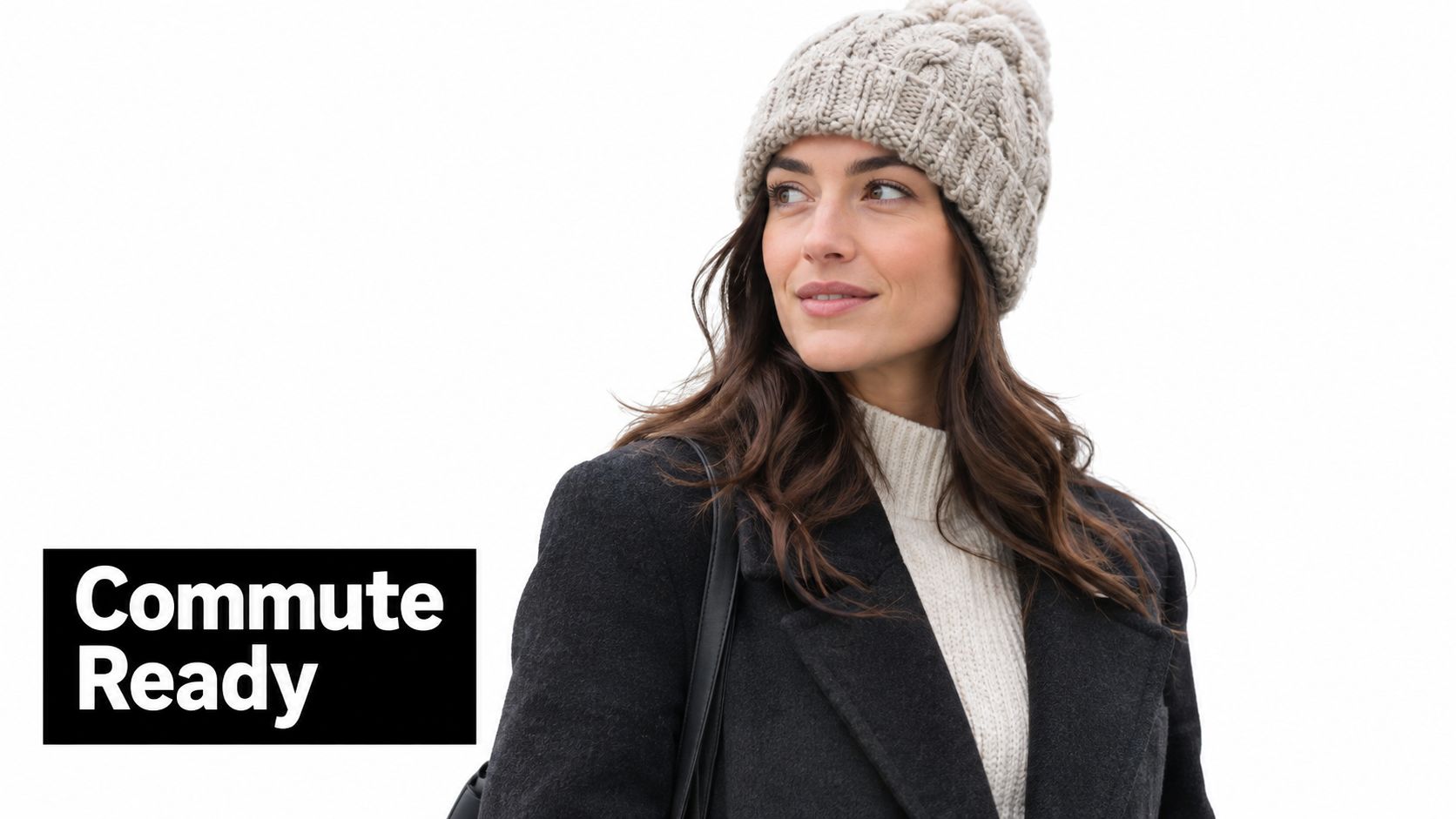 A woman wearing a beige cable knit beanie and a dark coat, looking away thoughtfully.