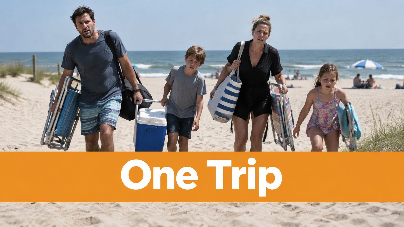 A family of four walking across the sand to the beach carrying chairs and beach gear.