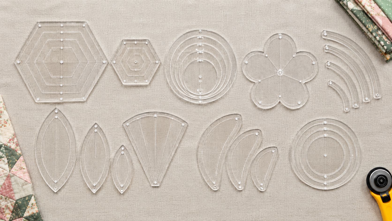 A collection of clear acrylic quilting templates in various creative shapes like hexagons and curves on a quilted background.