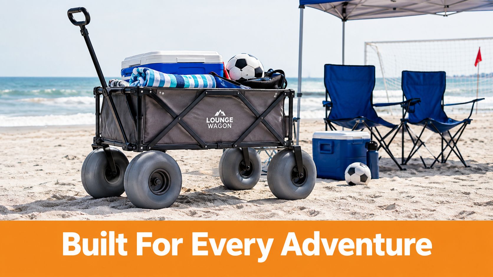 A gray folding wagon with large balloon tires parked on a sandy beach during a sunny day.
