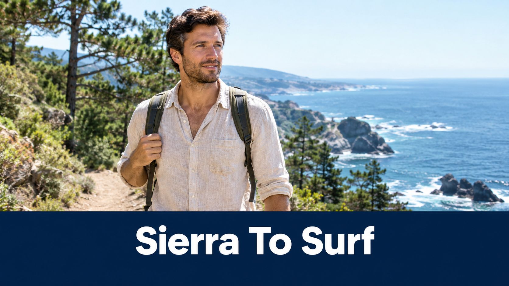A smiling man wearing a beige linen shirt and a backpack on a coastal hiking trail.