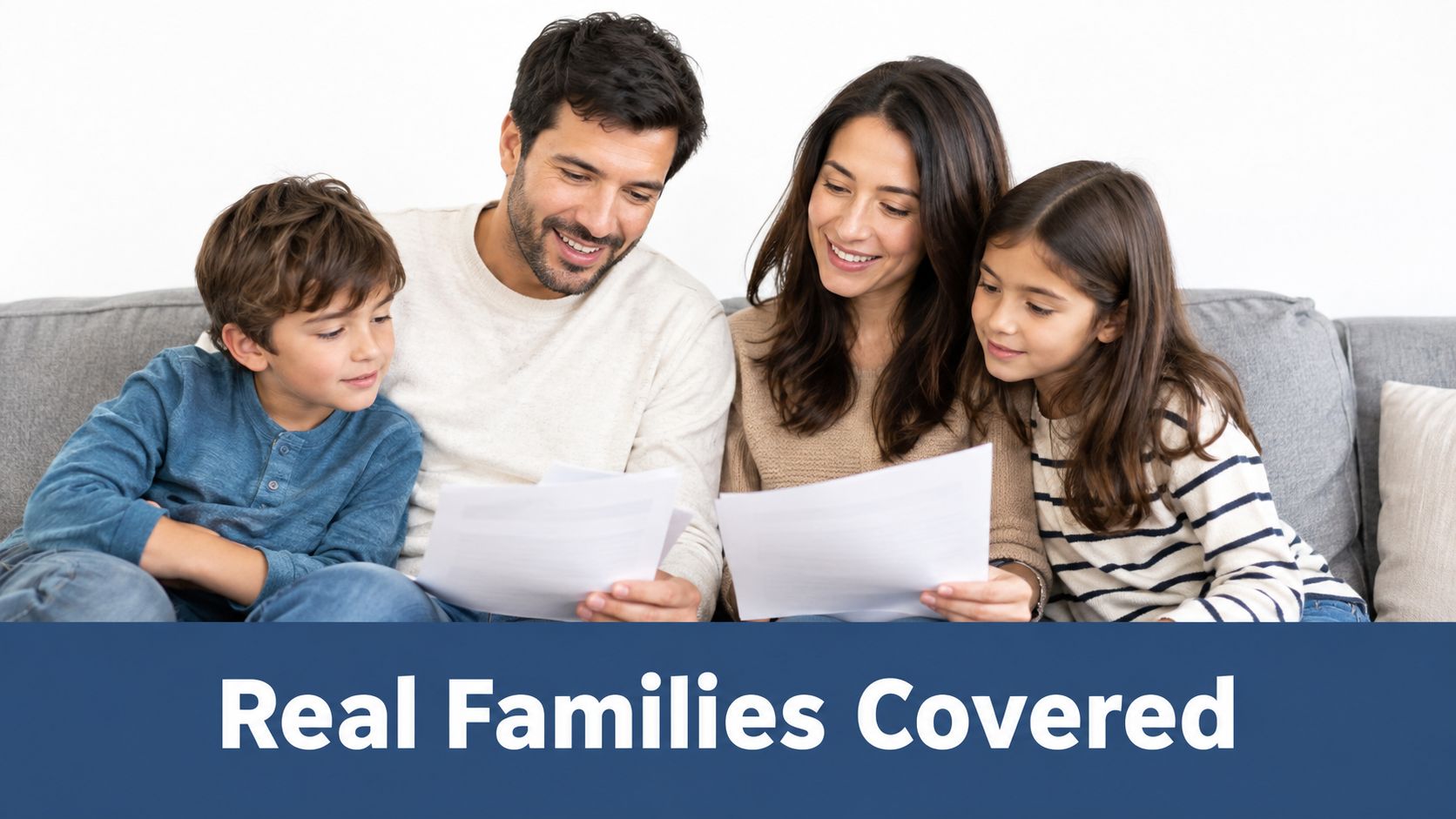 A happy family sitting on a couch together looking at life insurance documents in their home.