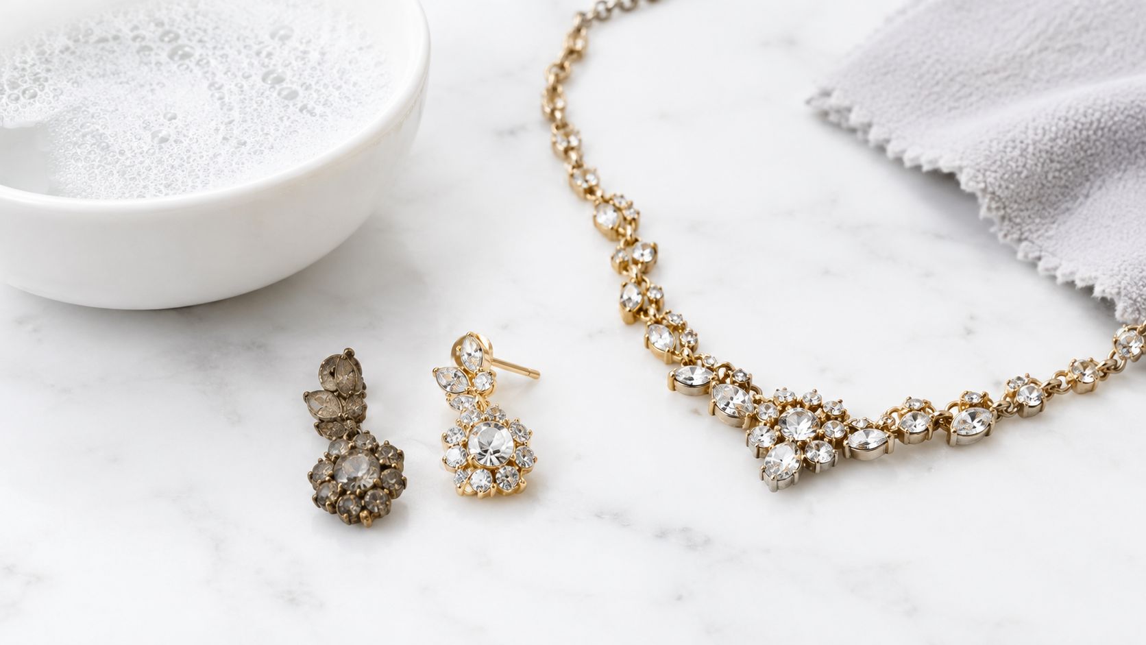 A close-up view of costume jewelry, including a necklace and earrings, next to a cleaning solution.