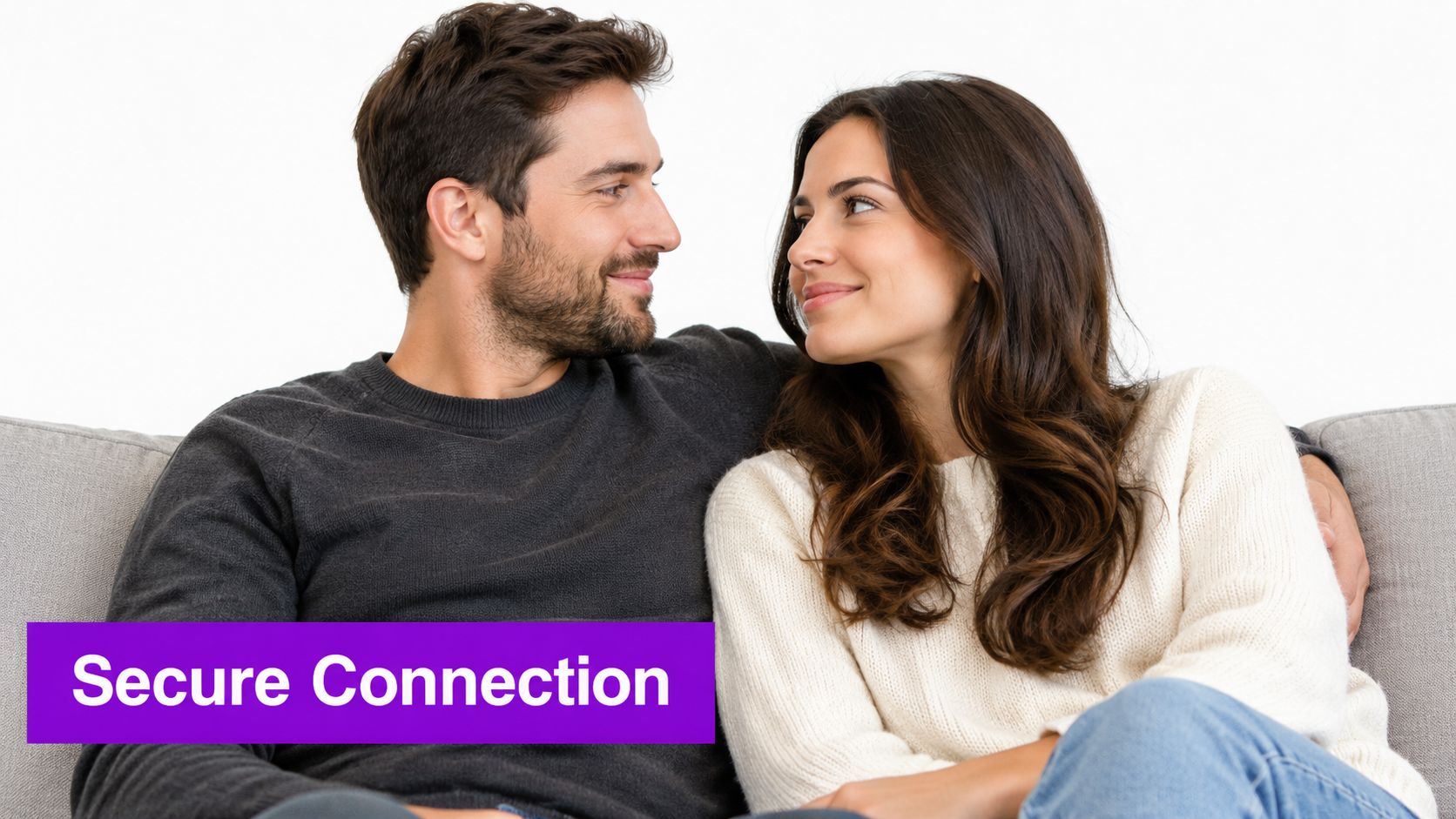 A happy couple sitting together on a couch, looking into each other's eyes with a loving expression.