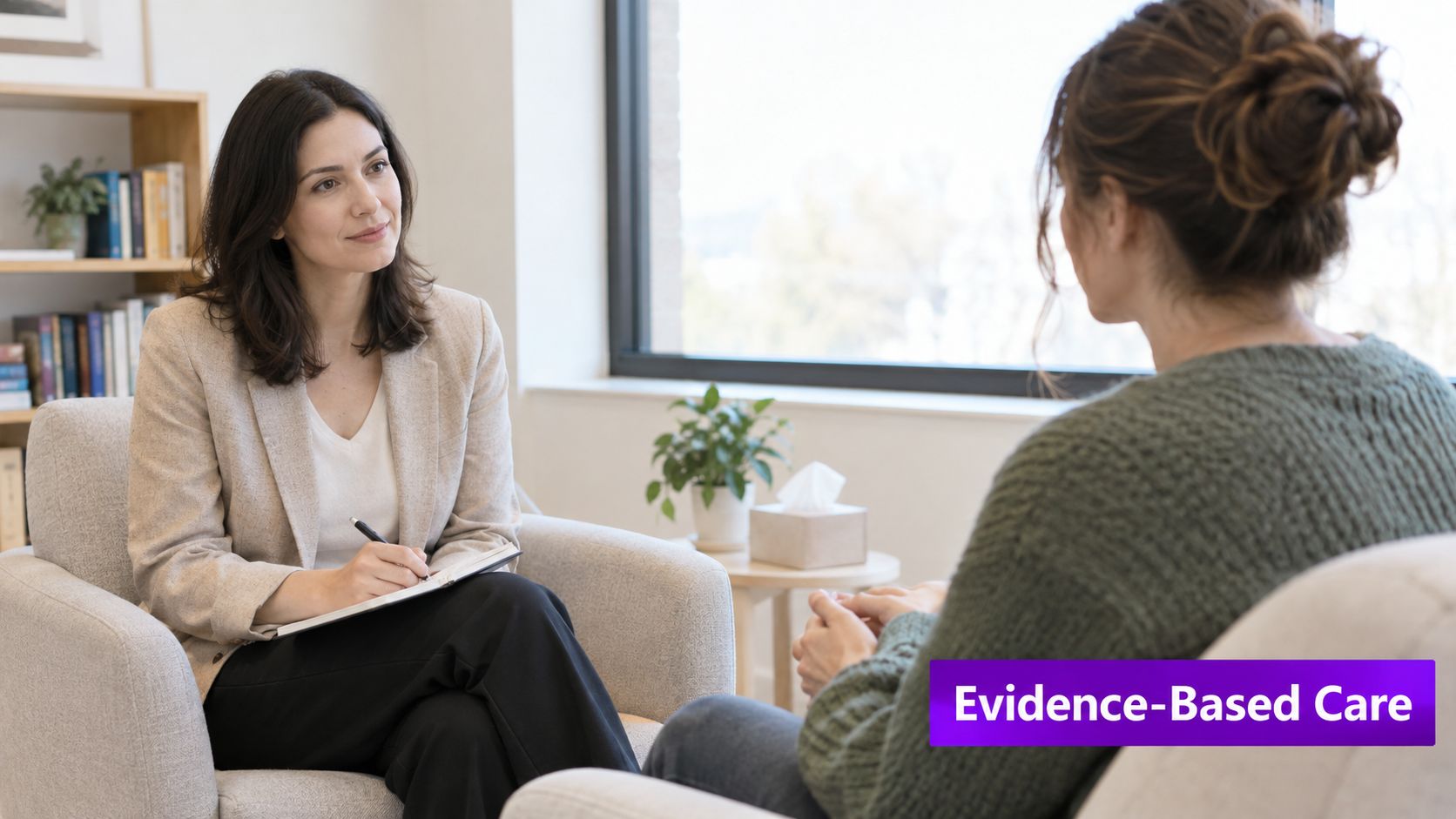 A professional therapist listens attentively while taking notes during a consultation with a patient in an office.