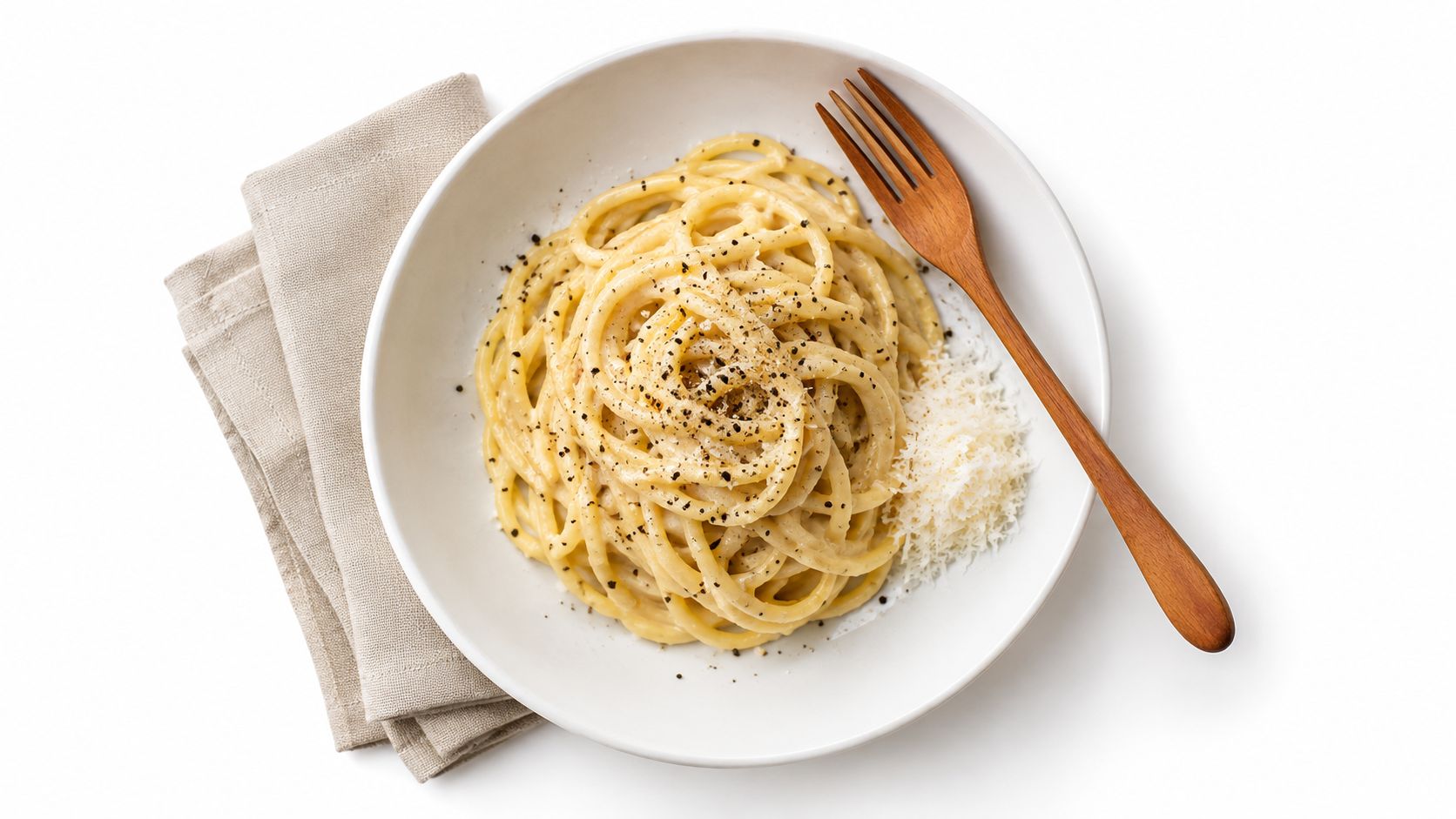 A top-down view of a bowl of creamy cacio e pepe pasta with a wooden fork.