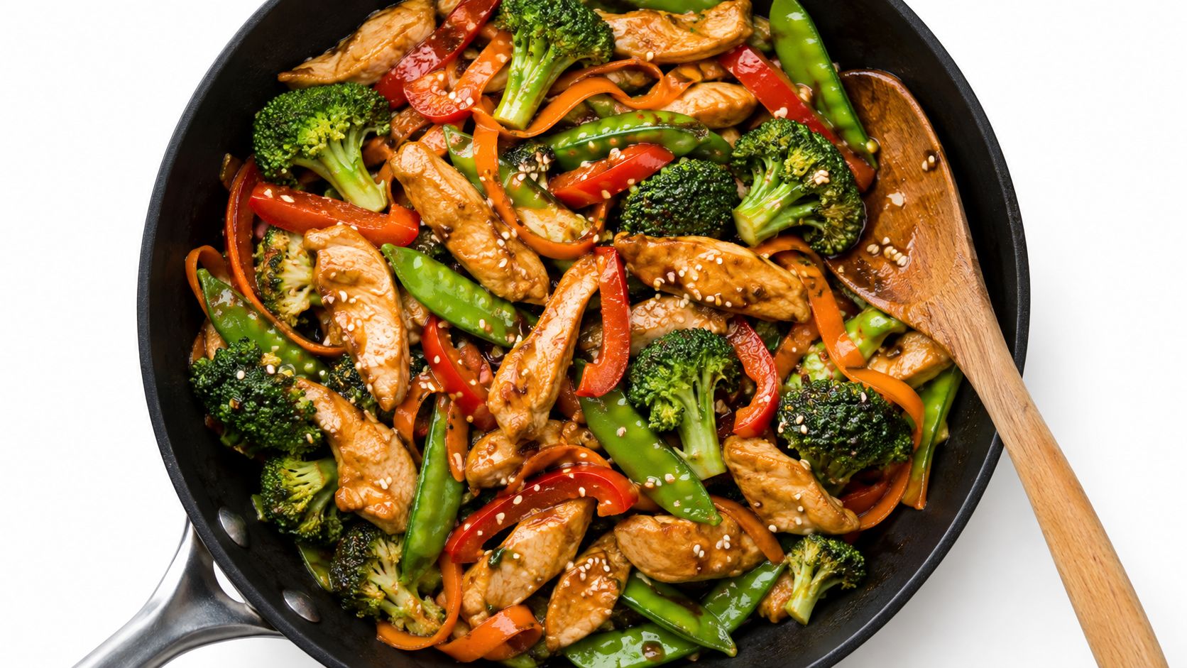 A delicious homemade chicken breast stir fry with fresh broccoli, red bell peppers, and snap peas in a skillet.