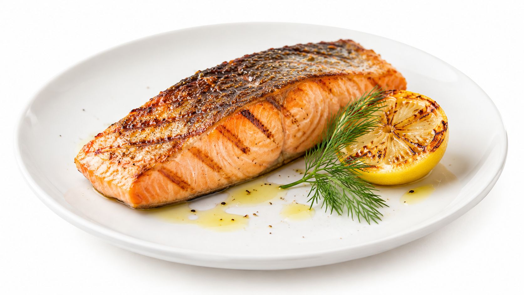 A perfectly grilled salmon fillet served on a white plate with a charred lemon slice and fresh dill.