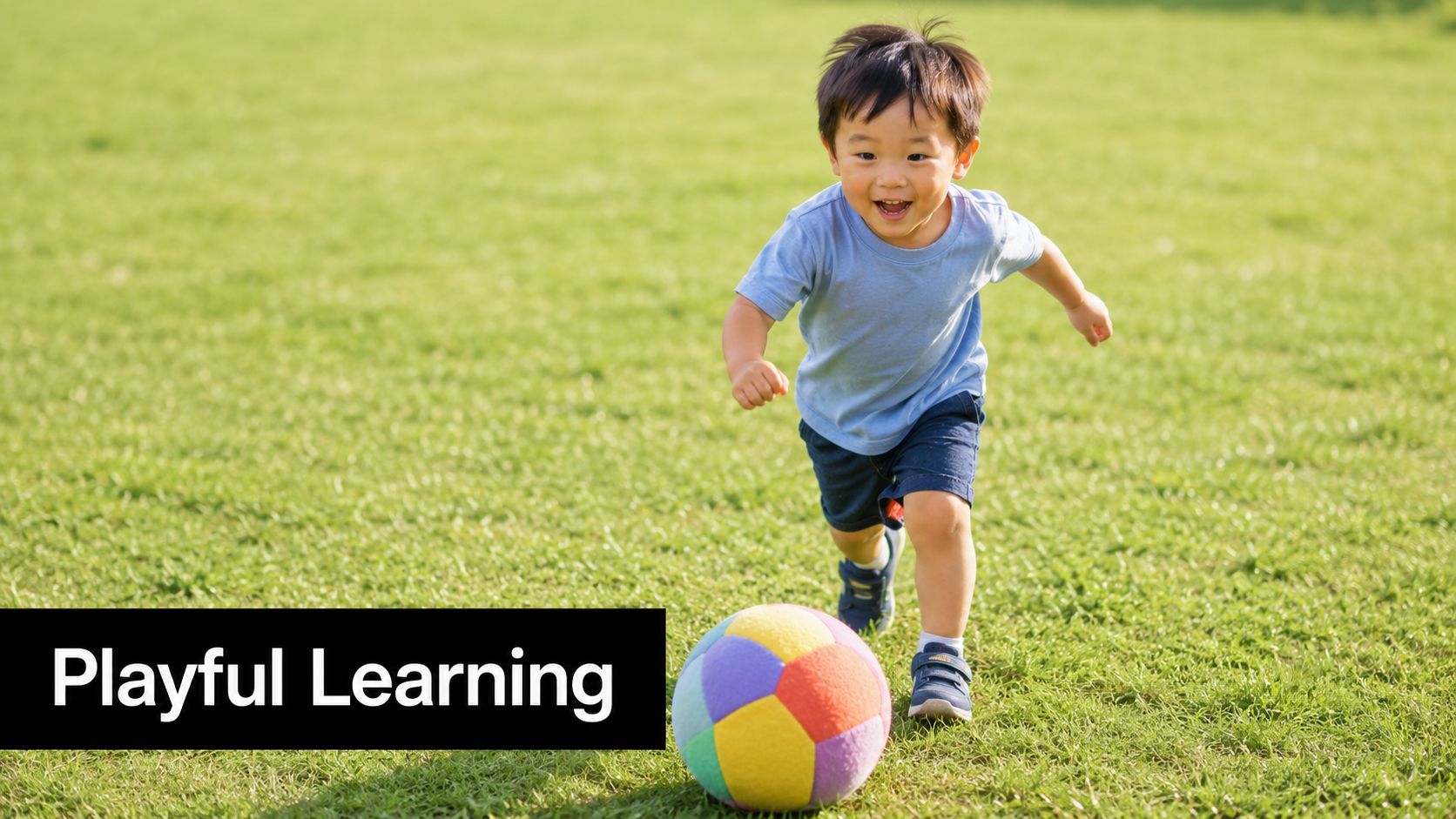A happy young boy in a blue shirt running across a sunny grass field with a ball.