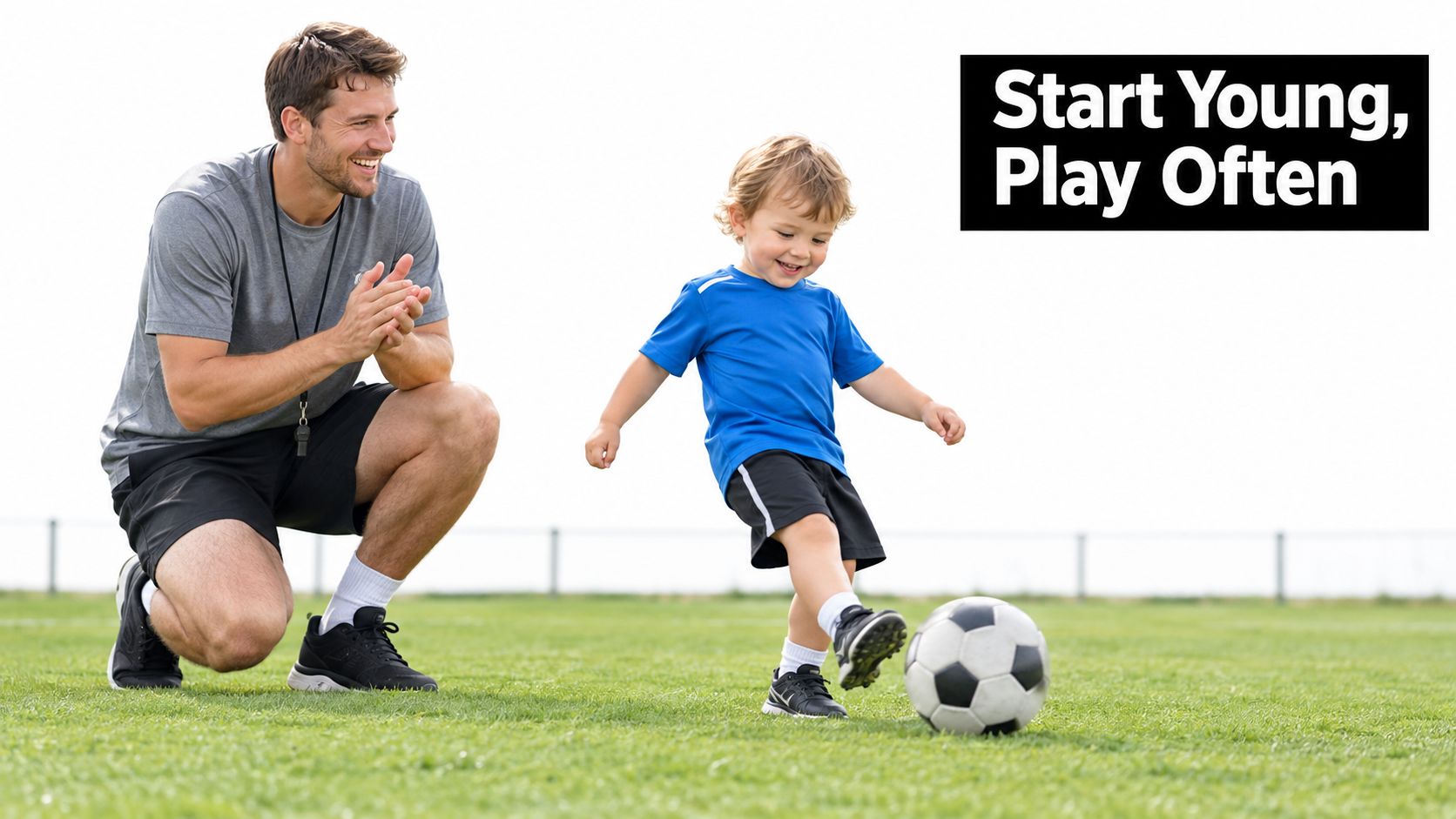 A friendly male soccer coach smiling as a young boy learns to kick a soccer ball