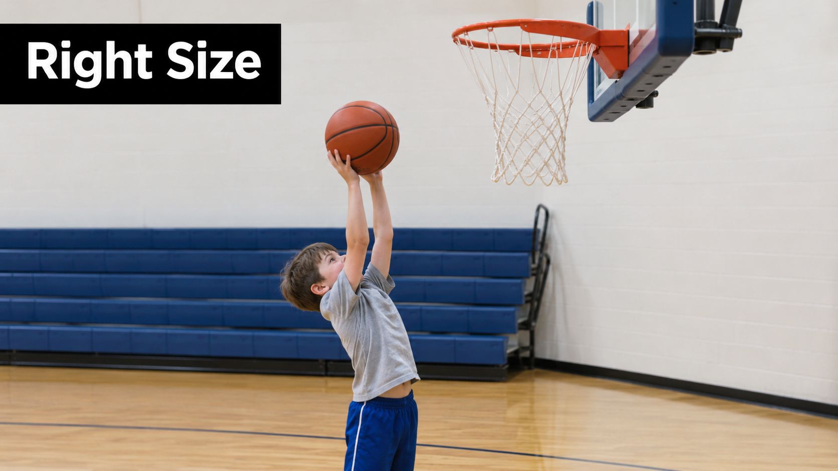 A young boy reaching up with a basketball toward a hoop in a gymnasium.