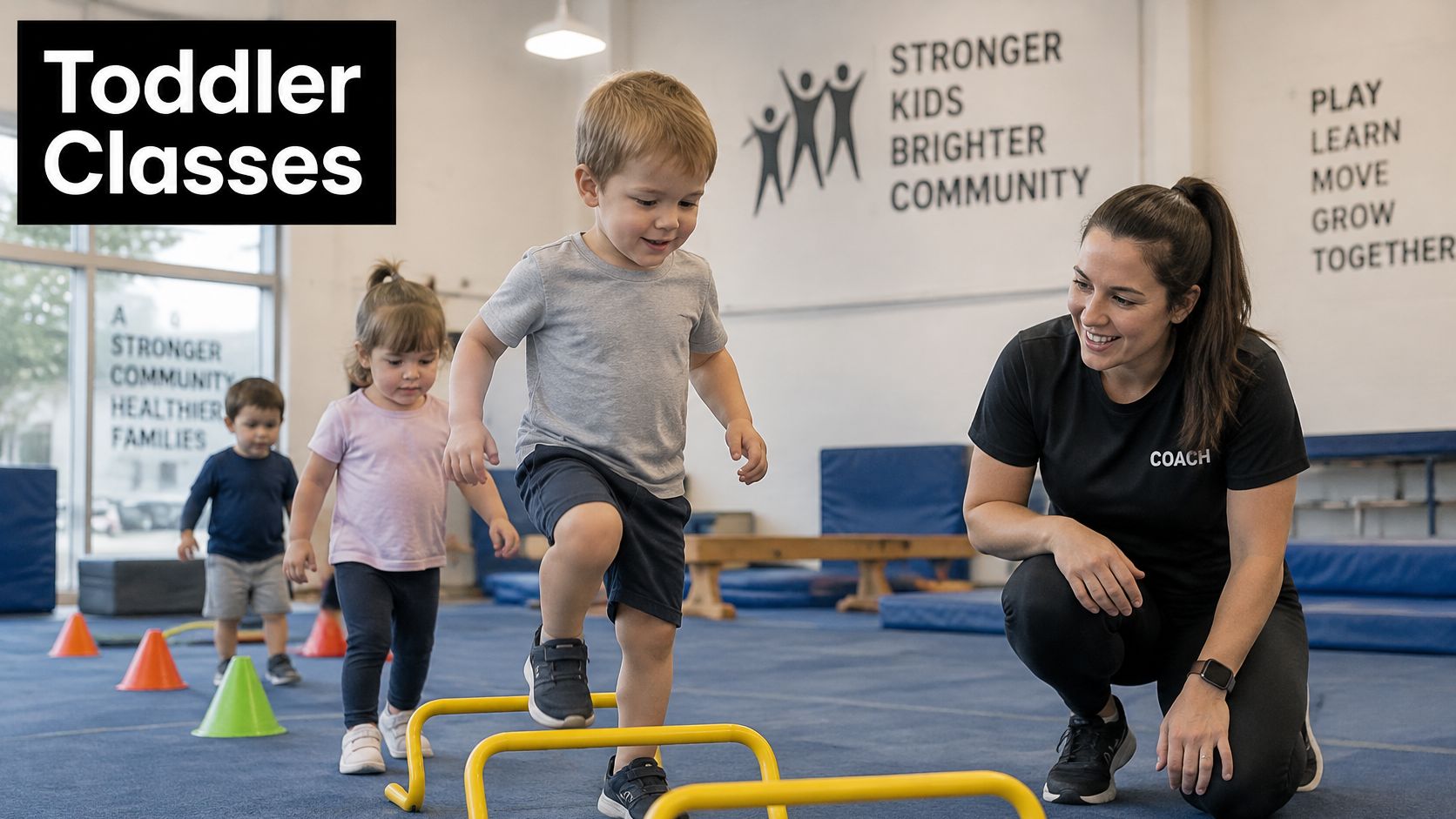 A female coach watching toddlers participate in a fun physical exercise class inside a gym.
