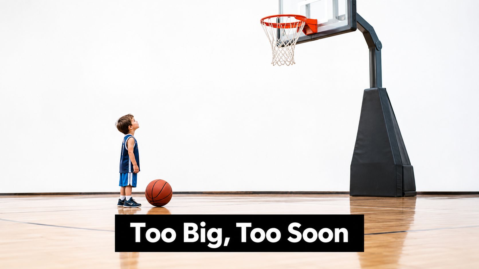 A small young boy in a basketball jersey looking up at a very high basketball hoop.