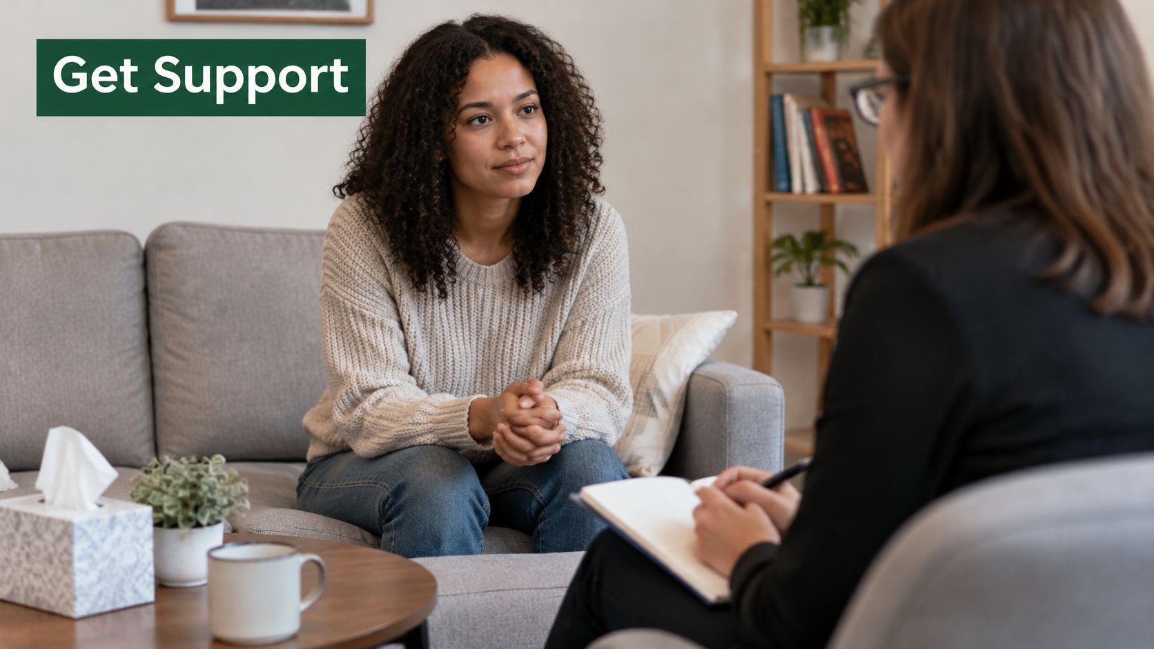 A young woman sitting on a couch talking to her therapist during a counseling session.