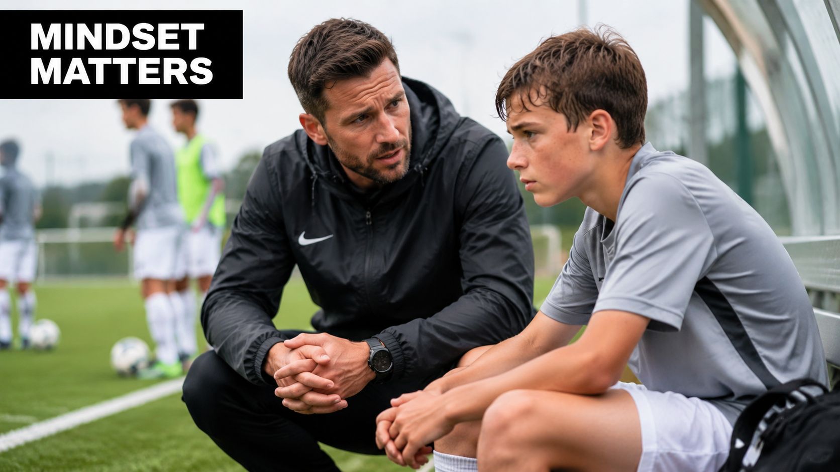 A professional coach giving supportive guidance to a young soccer player during a training session on field.