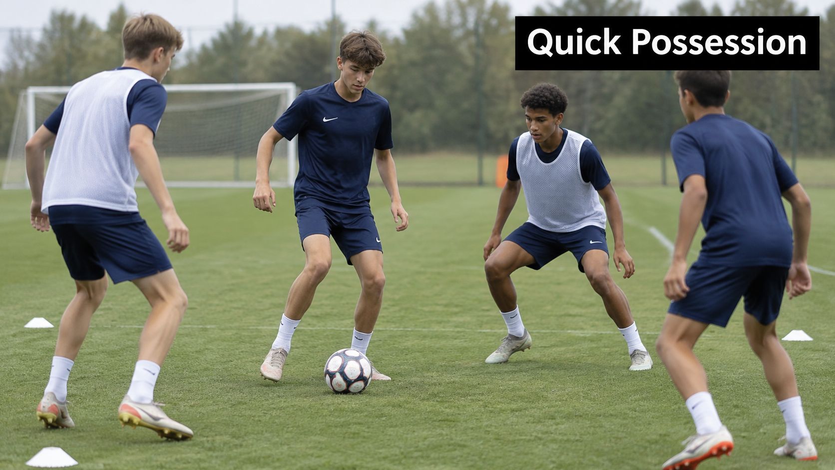 Four soccer players in training kits practicing possession drills on a lush green grass field.