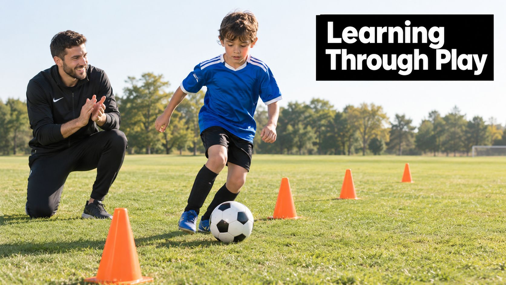 A young boy practices soccer drills with his coach on a sunny field with orange cones.