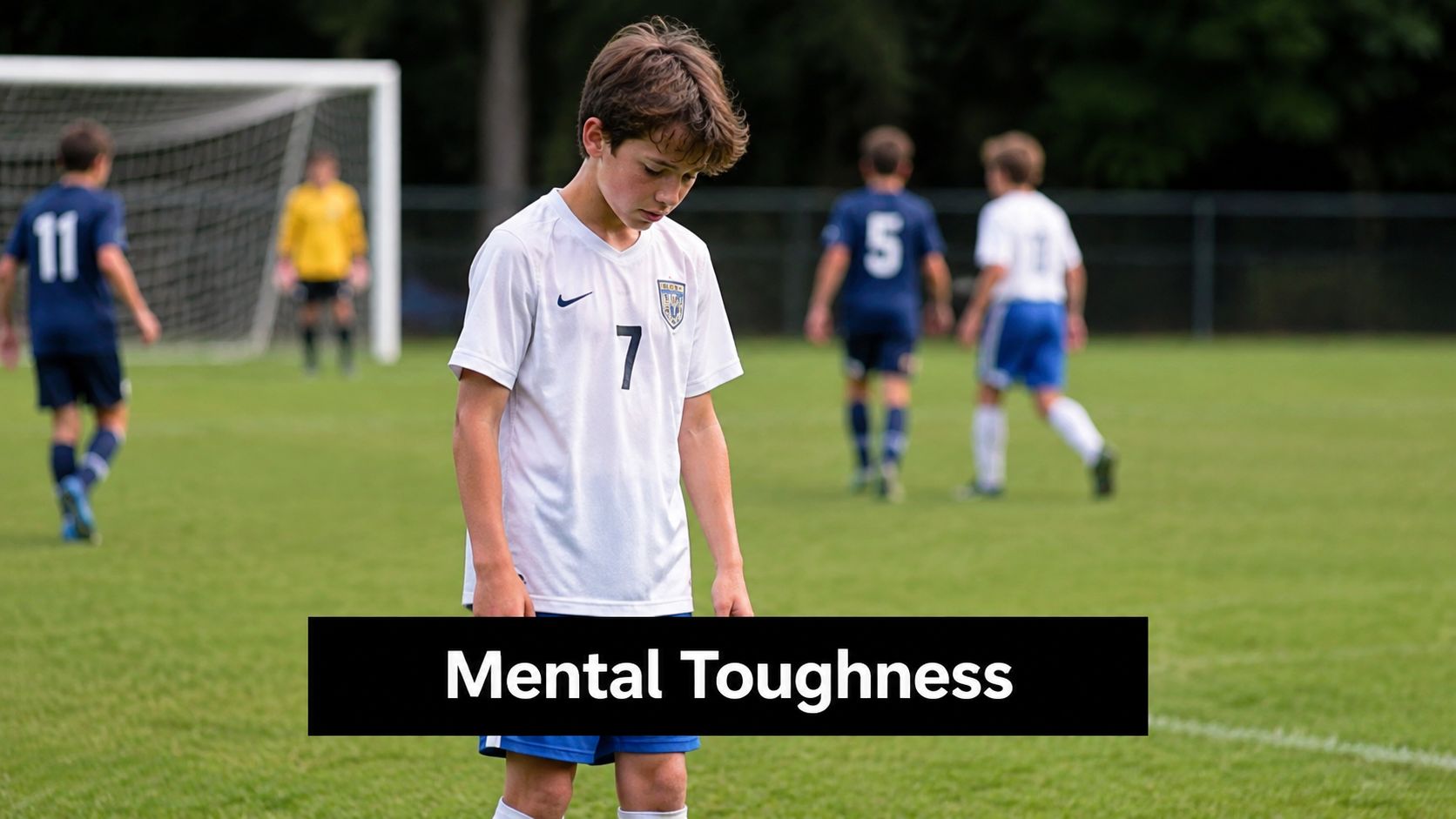 A young soccer player looking down with a dejected expression during a youth sports match.
