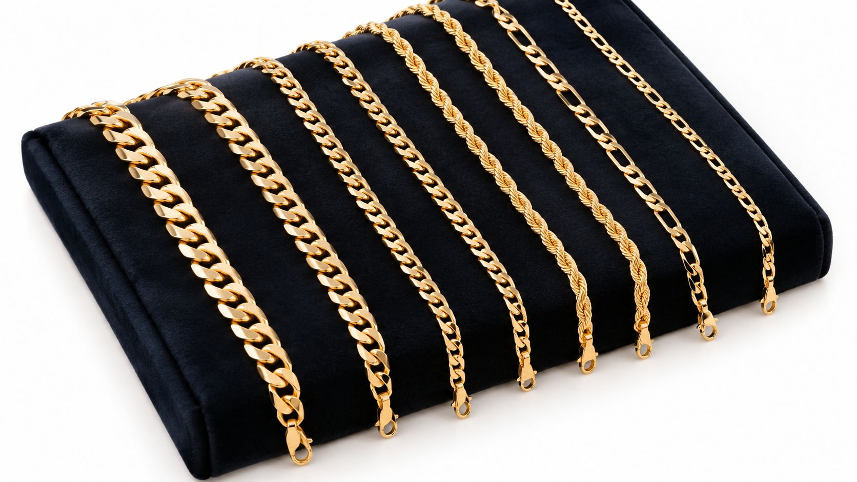 Plusieurs chaînes en or brillantes pour hommes, présentées sur un élégant présentoir en velours noir sur fond blanc.