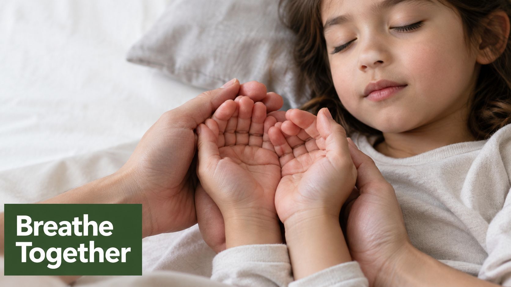 A caring parent gently holds the small hands of a peaceful sleeping child in a calm bedroom.