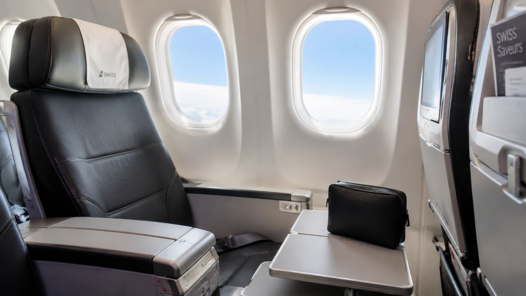 Inside a Swiss International Air Lines business class cabin featuring leather seats and personal amenity kit.
