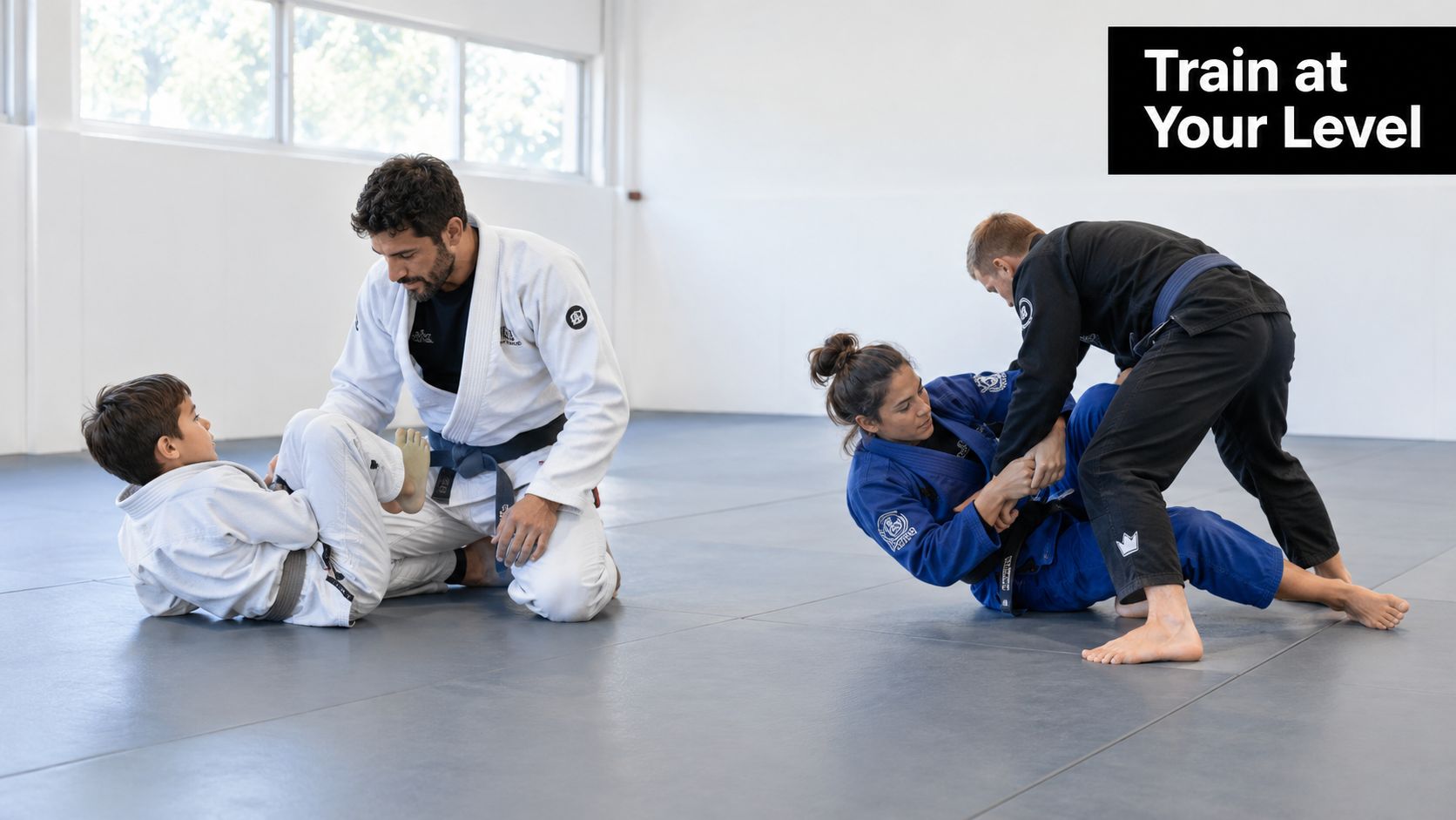 A professional instructor training a child and a pair of adults practicing Brazilian Jiu-Jitsu on mats.