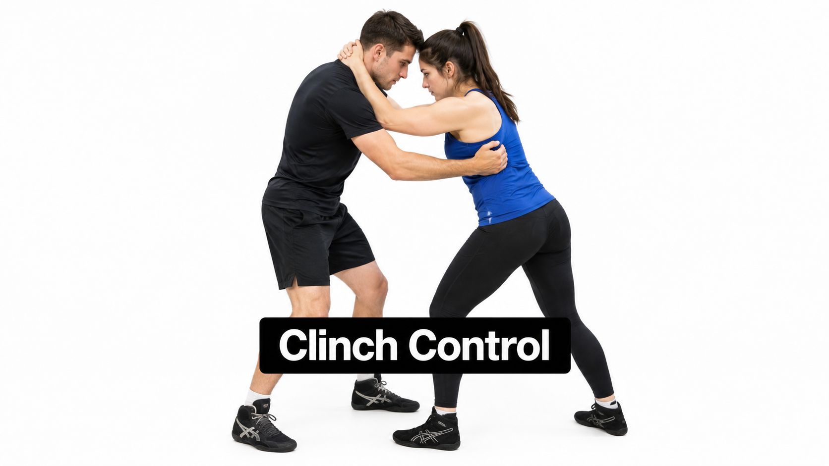 A martial arts instructor and student demonstrating a clinch control technique in a gym setting.