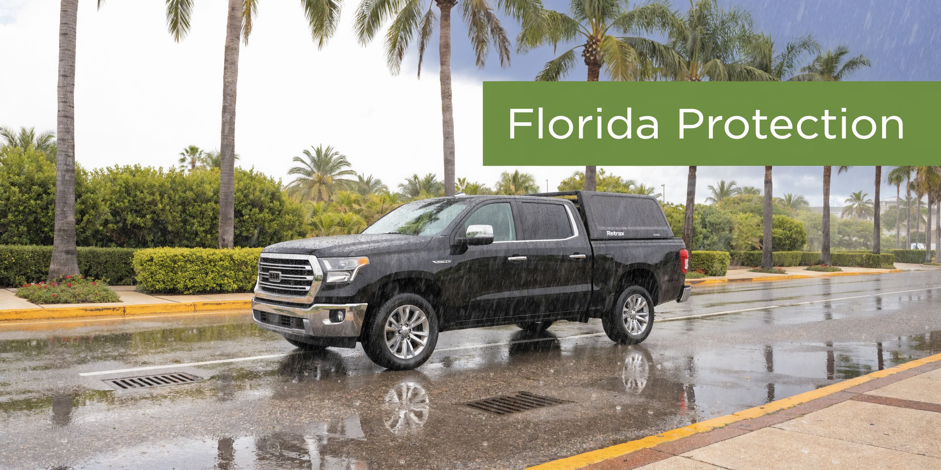 A black pickup truck featuring a Retrax retractable tonneau cover parked on a wet road during rain.