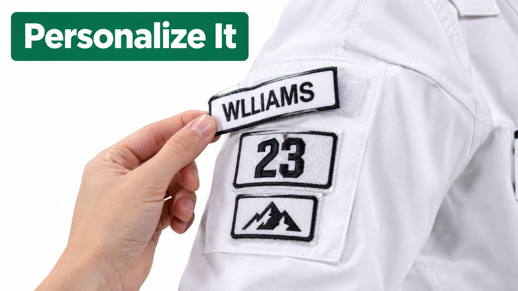 A hand placing a personalized name patch onto a white uniform sleeve with mountain and number patches.