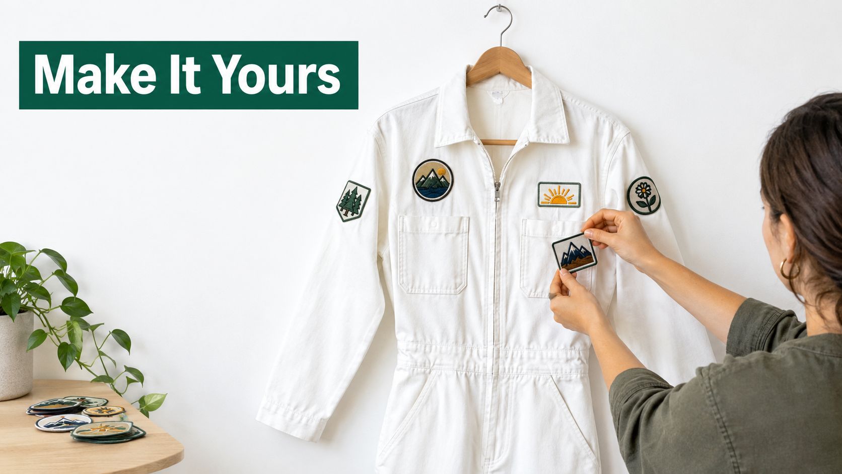 A woman personalizing a white jumpsuit by applying various embroidered patches to the fabric.