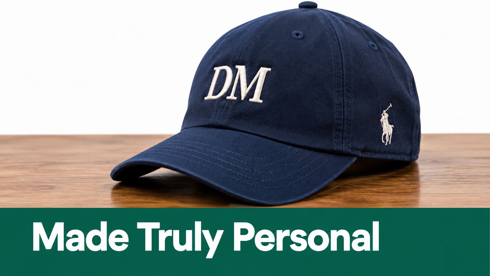 A navy blue baseball cap embroidered with the letters DM, displayed on a wooden surface.