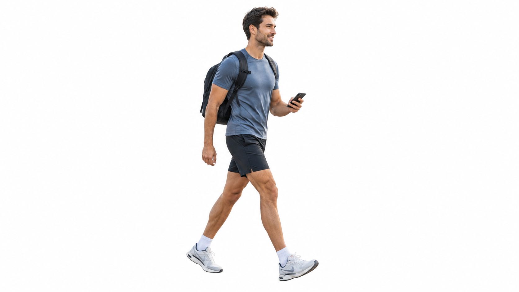 A fit man wearing a t-shirt and shorts walks while holding a smartphone and carrying a backpack.