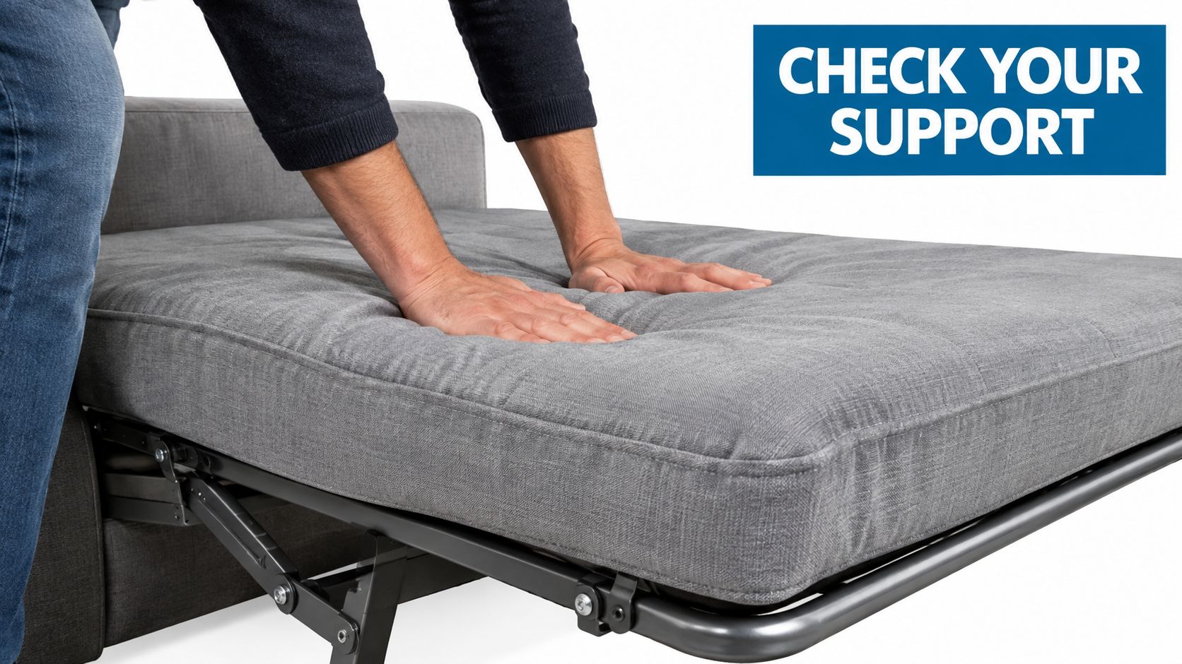 A person testing the firmness and support of a pull-out sofa bed mattress with their hands.