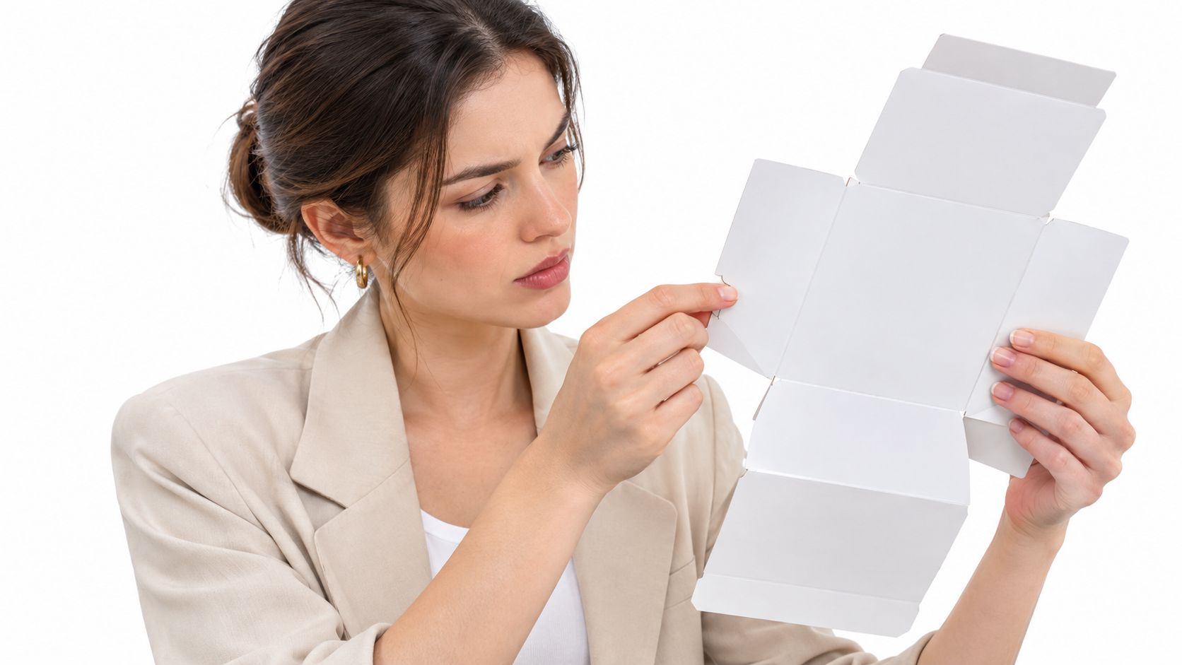 Eine Frau in einem beigen Blazer hält eine leere, flach ausgebreitete weiße Verpackung in ihren Händen.