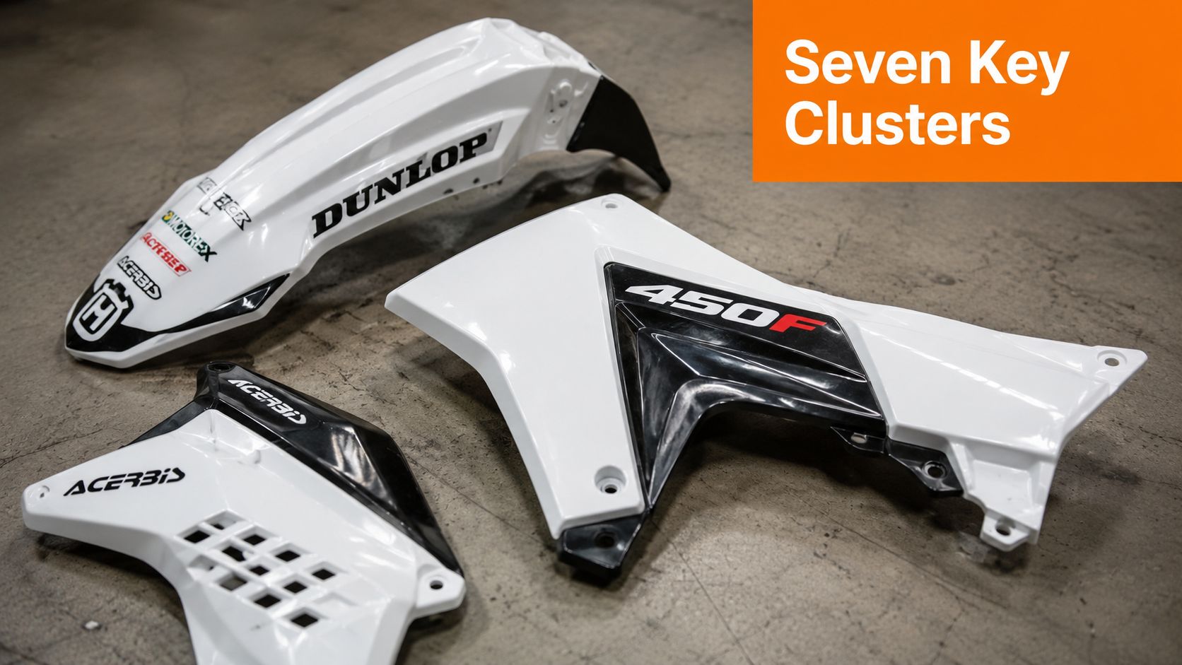 A set of white and black motocross bike plastic bodywork parts displayed on a concrete floor.