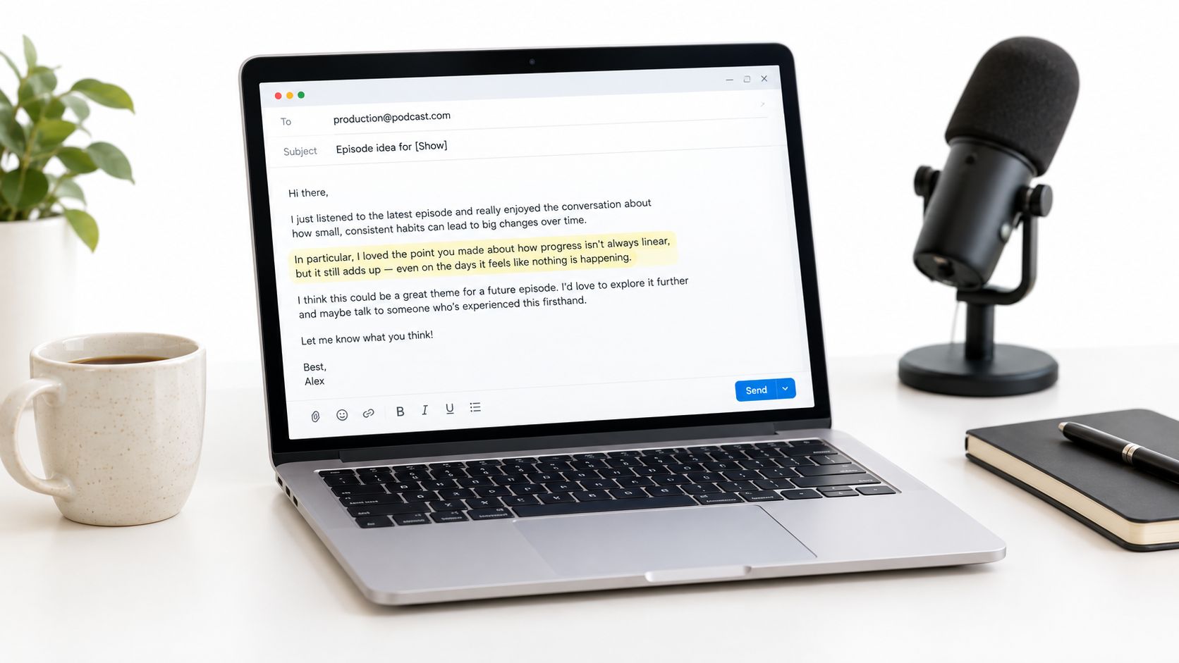 A modern laptop on a desk showing an email pitch for a podcast episode idea next to a microphone.