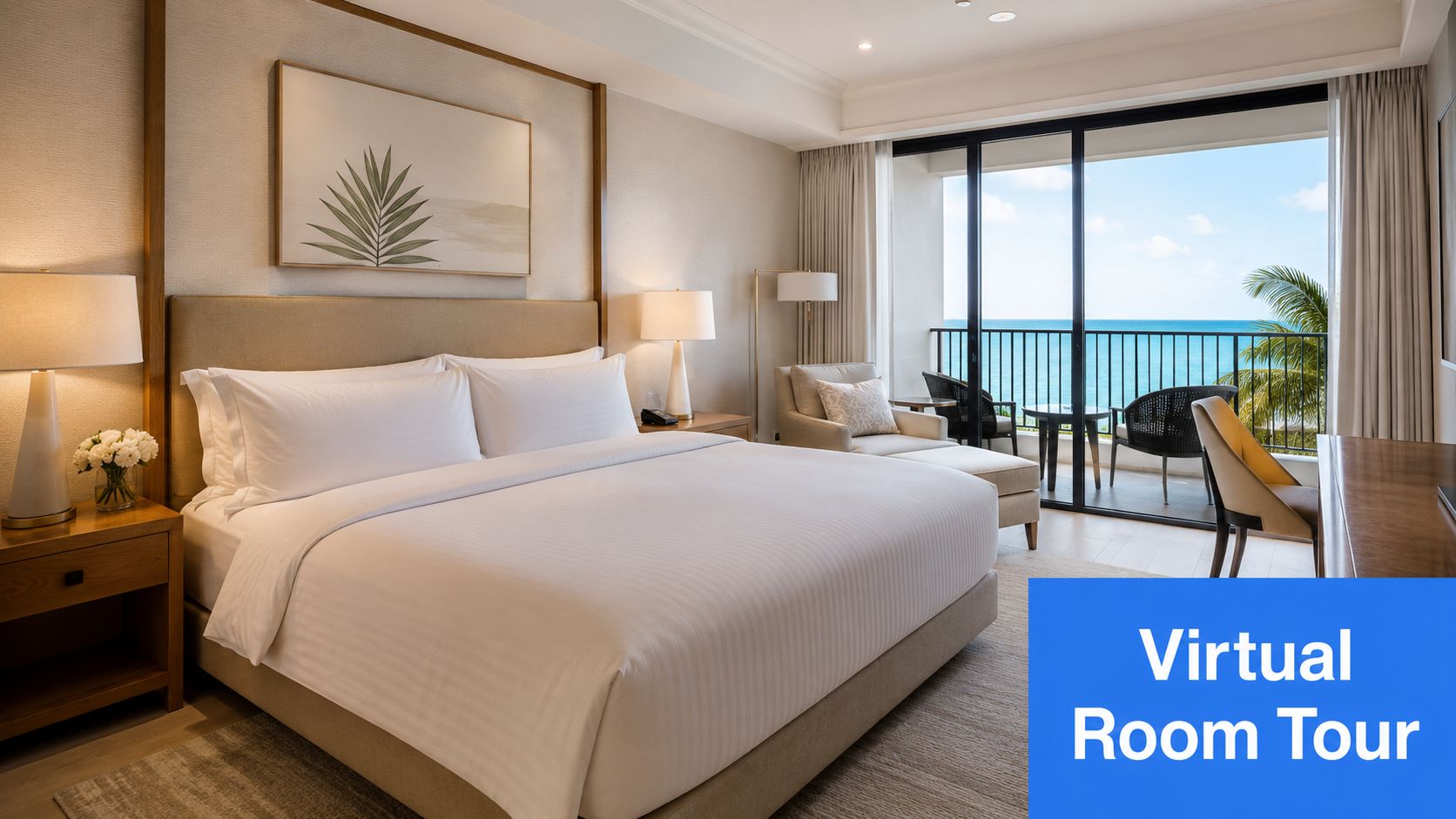 A luxurious hotel bedroom with a large bed, balcony view of the ocean, and a desk area.
