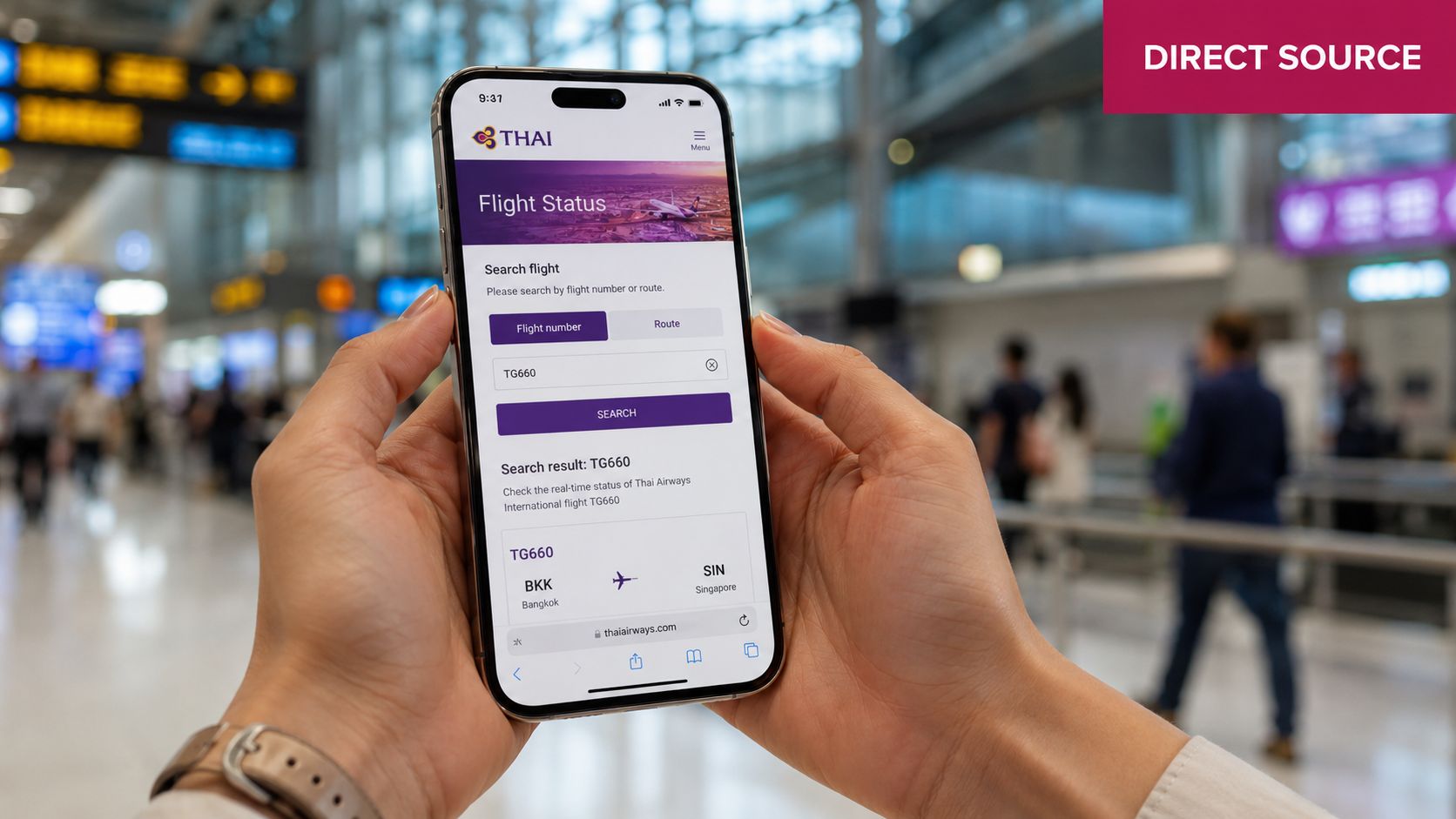 A person holding a smartphone displaying the Thai Airways flight status search page in an airport terminal.