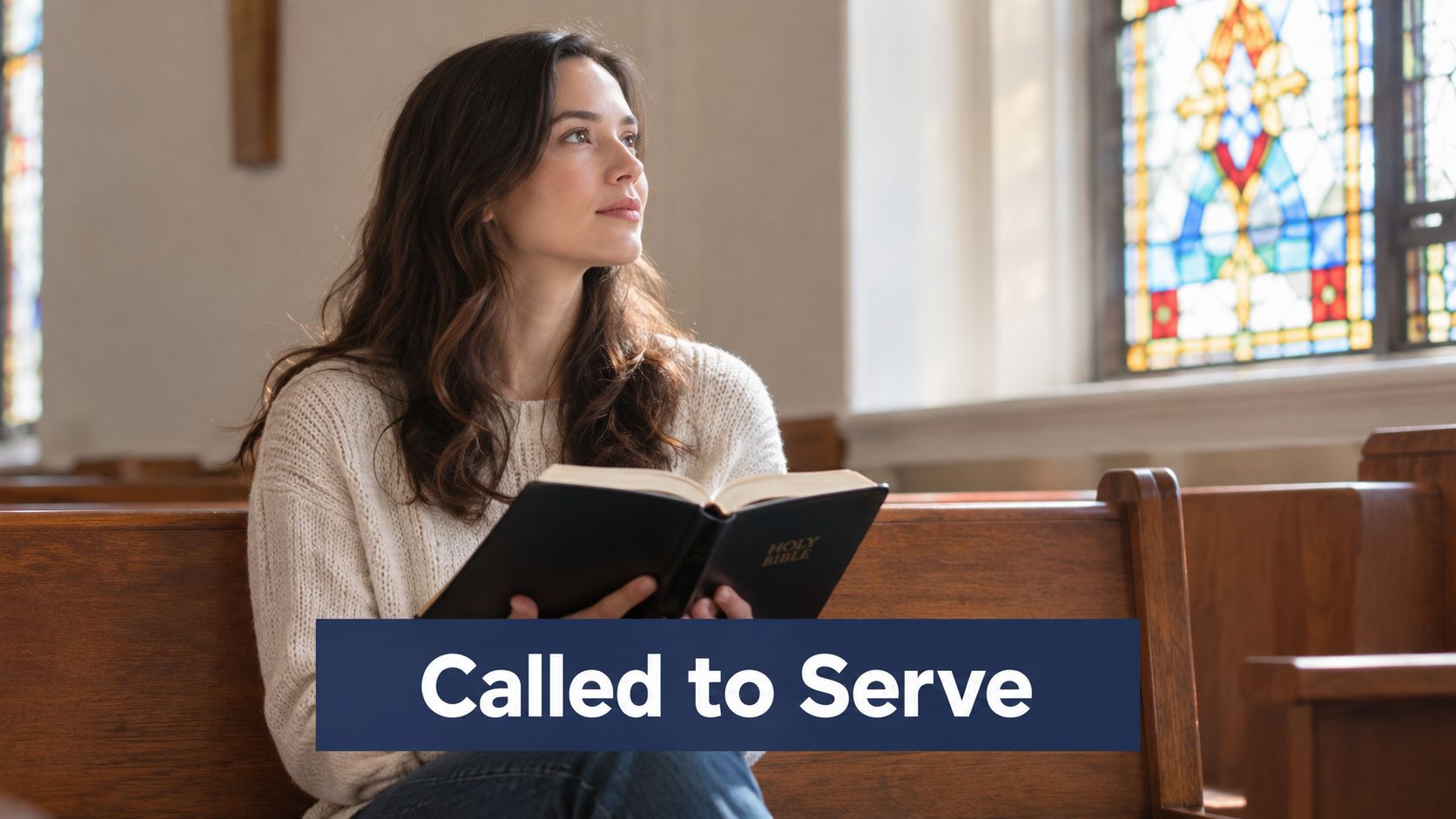 A woman holding a Bible while sitting in a church pew looking up with a thoughtful expression.