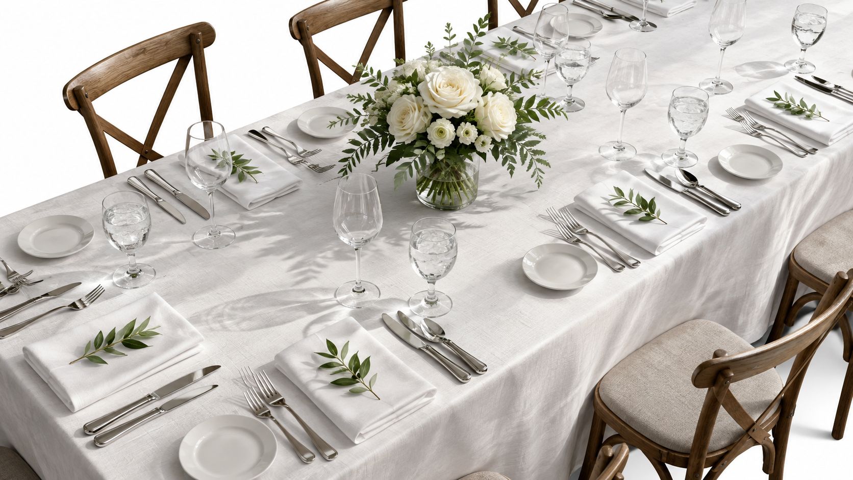 Una mesa elegantemente decorada con manteles blancos, vajilla fina, cubiertos plateados y un centro de rosas blancas.