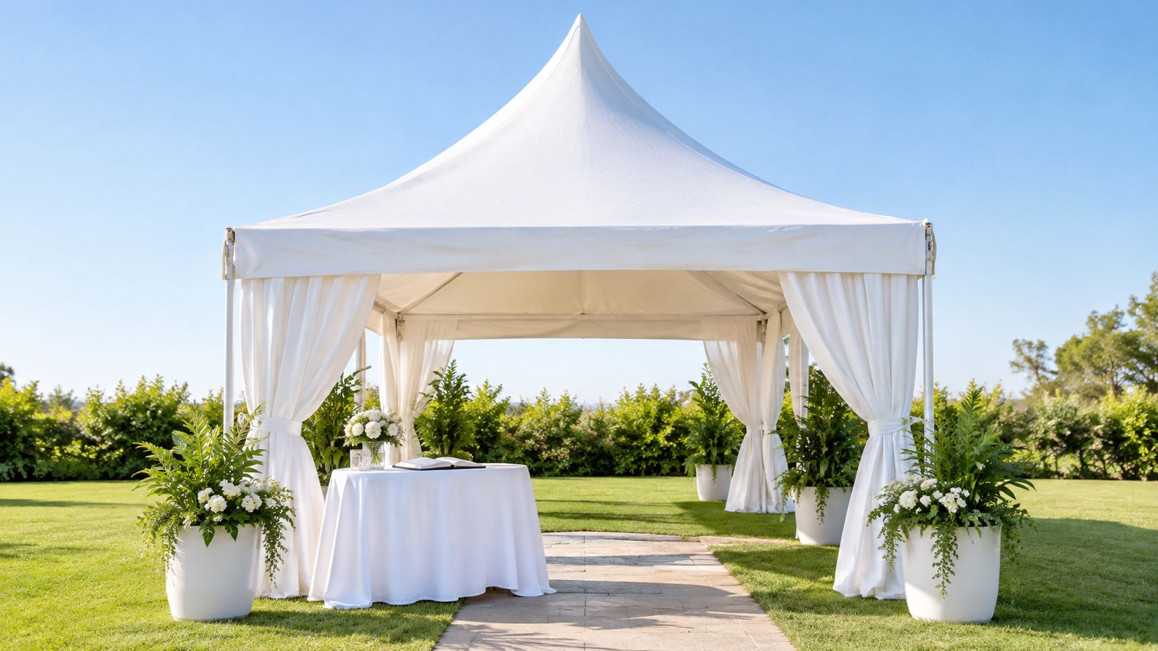 Elegante carpa blanca con decoración floral y mesa para eventos al aire libre en un jardín.