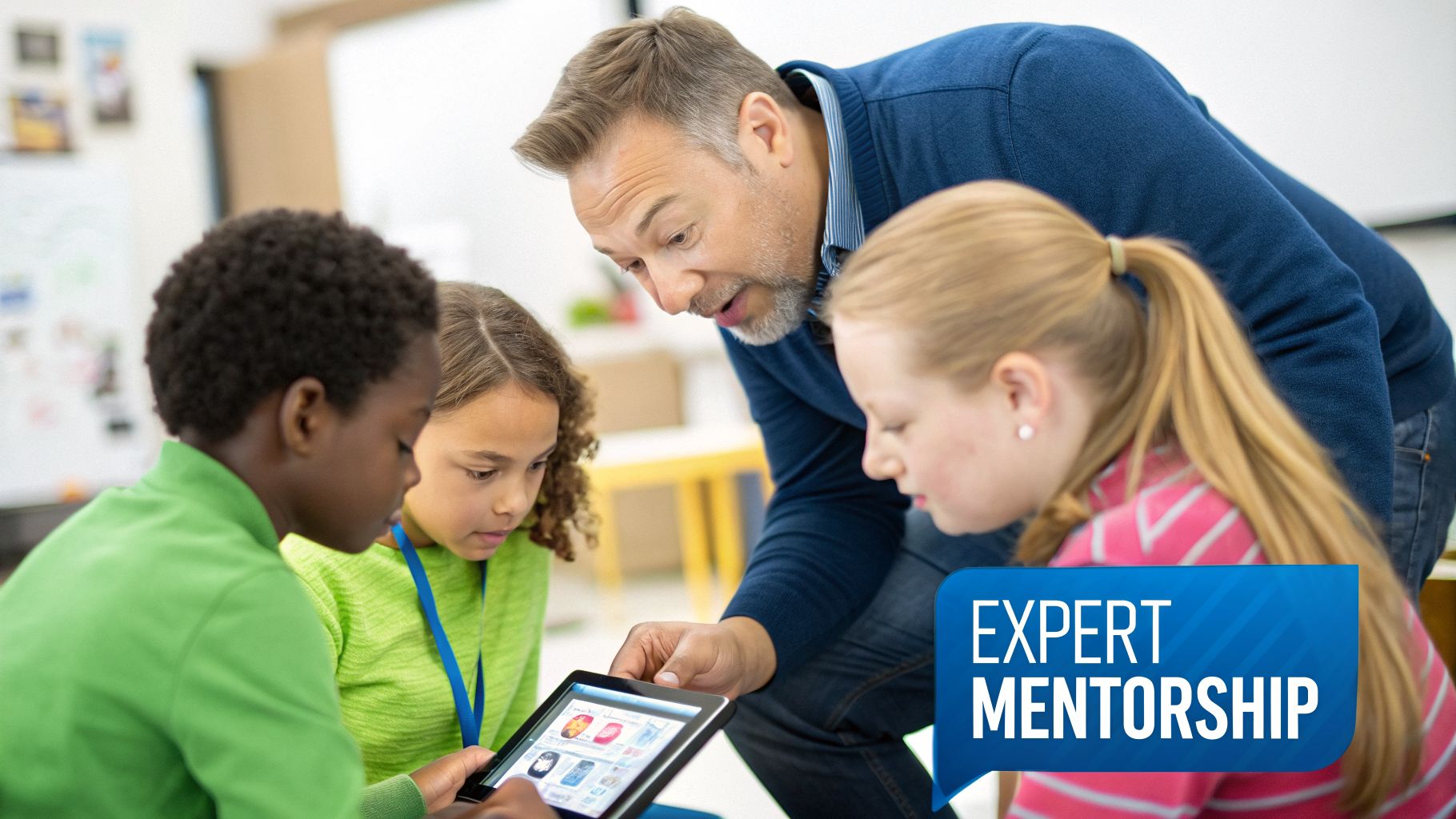 A male mentor guides three diverse students using a tablet in a classroom, emphasizing expert mentorship.