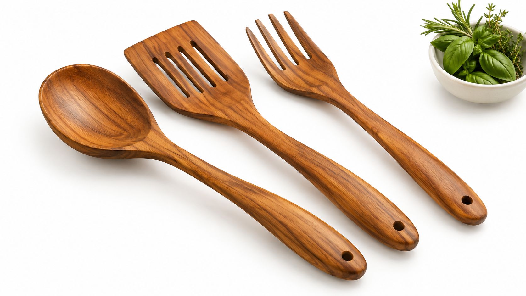A high-quality teak wooden utensil set featuring a spoon, a slotted turner, and a fork on white.