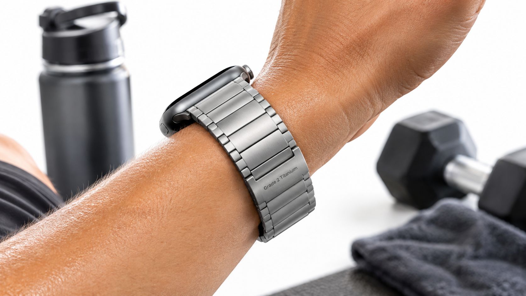 A close-up view of an Apple Watch with a metallic titanium band worn on a person's wrist.