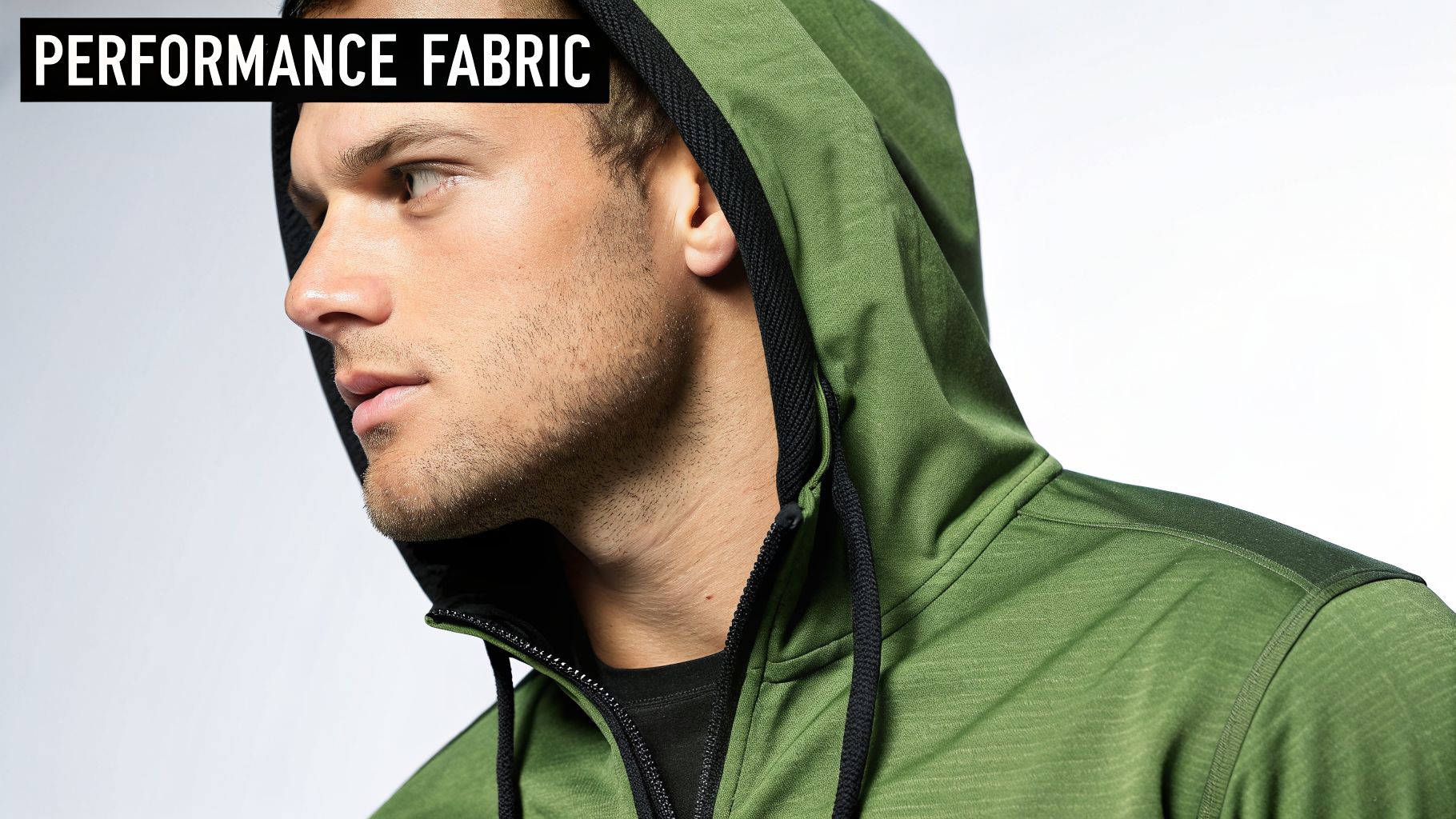 A man in profile wearing a green performance fabric hoodie with a black zipper and drawstrings.