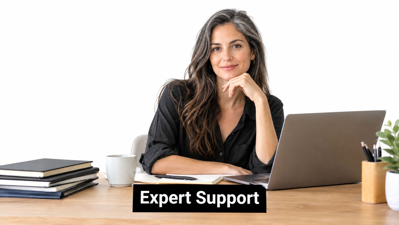 A professional businesswoman with long hair sitting at her office desk with a laptop and documents.