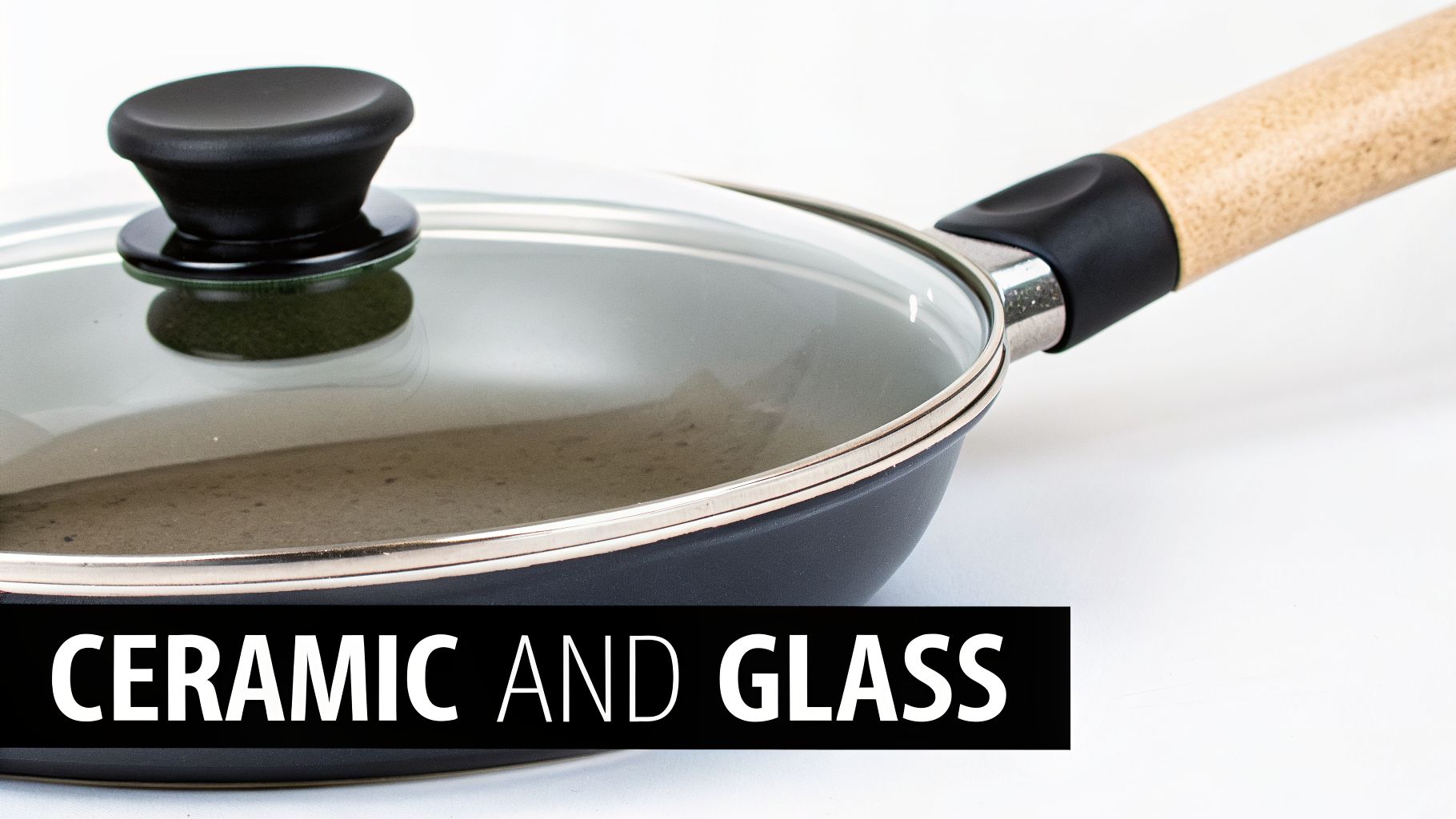 Close-up of a black ceramic frying pan with a clear glass lid and wooden handle on white.